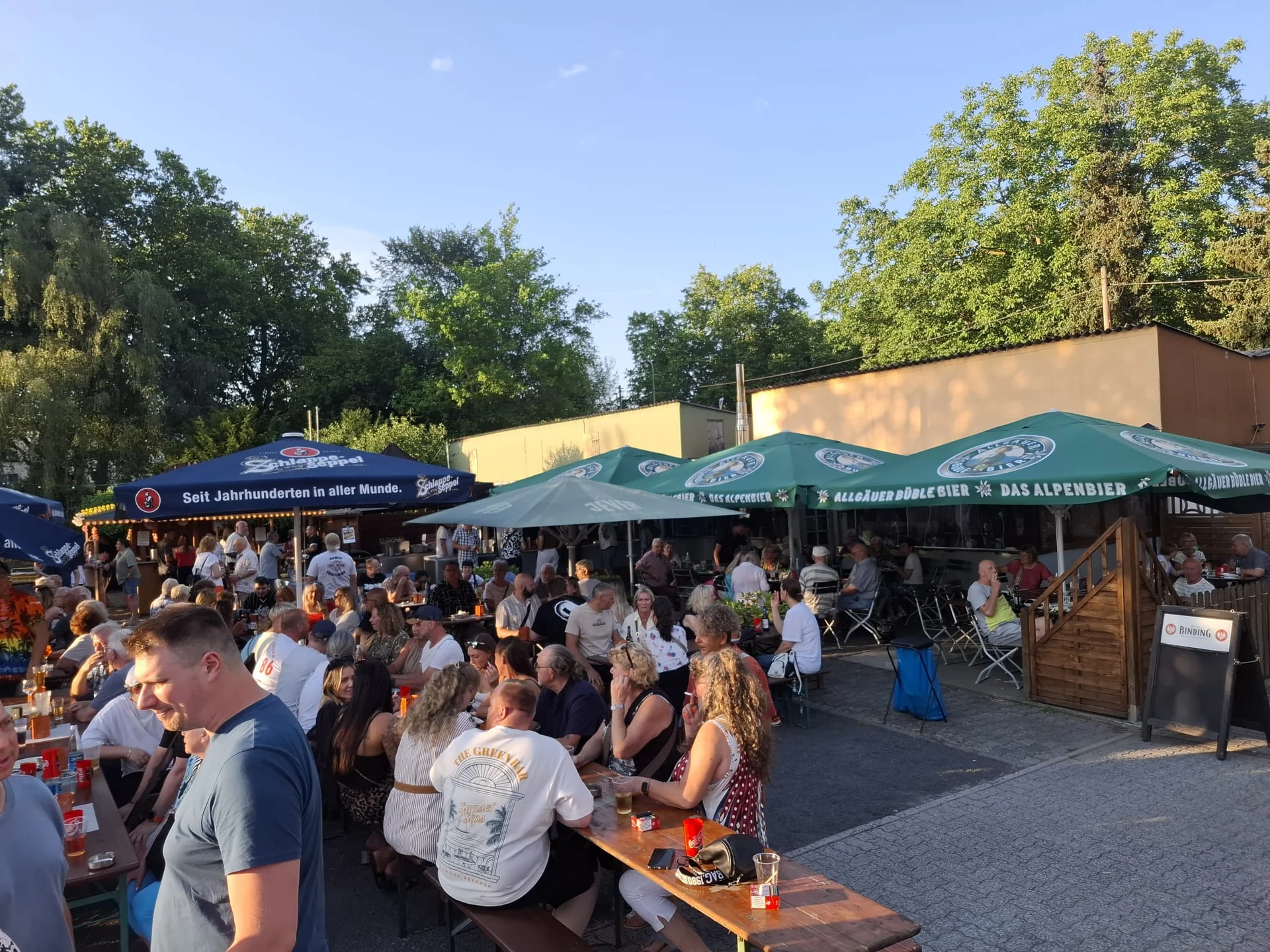 Gäste im Sonnenschein vor dem Vereinslokal